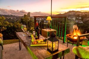 a table with a glass of wine and a fire pit at Casablanca Hotel Boutique in Campos do Jordão