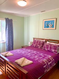 um quarto com uma cama grande e lençóis roxos em Cottage 55 - Topspot Cottages em Jurien Bay