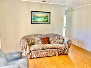 um sofá sentado numa sala de estar com um quadro em Cottage 55 - Topspot Cottages em Jurien Bay
