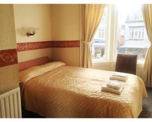 a bedroom with a bed with two towels on it at St Elmo Hotel in Blackpool