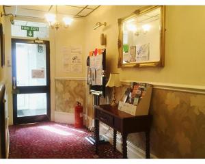een hoek van een kamer met een bureau en een spiegel bij St Elmo Hotel in Blackpool