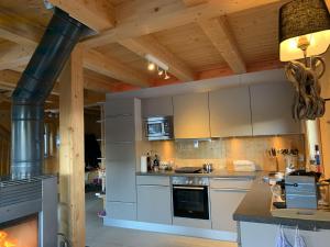 uma cozinha com armários brancos e um forno com placa de fogão em Chalet Claassen em Brandstätter