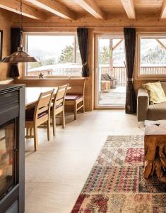 a living room with a fireplace and a table and chairs at Chalet Claassen in Brandstätter