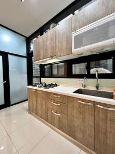 a kitchen with wooden cabinets and a sink at Lan Feng Su B&B in Yilan City