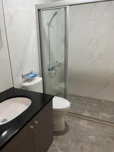 a bathroom with a shower and a toilet and a sink at Lan Feng Su B&B in Yilan City