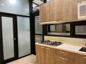 宜蘭市的住宿－嵐峰宿（全新包棟14人），厨房配有木制橱柜和炉灶烤箱。