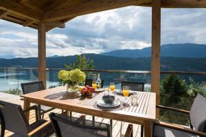a table on a deck with a view of the mountains at Chalet Seeblick in Millstatt