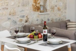 een tafel met een fles wijn en een fruitschaal bij The Stone House Naxos in Glinado Naxos