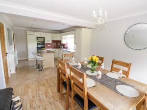 een eetkamer en een keuken met een tafel en stoelen bij Kilkeeran Lodge in Partry