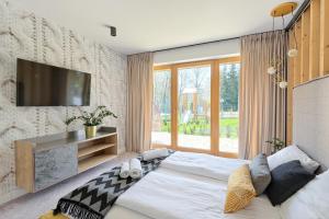 1 dormitorio con 1 cama grande y TV en la pared en Rezydencja Diamond - 3 minuty jazdy od Termy Bania, en Białka Tatrzanska