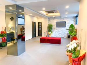 a lobby with a red couch and a brick wall at HOTEL LiVEMAX Okayama West in Okayama
