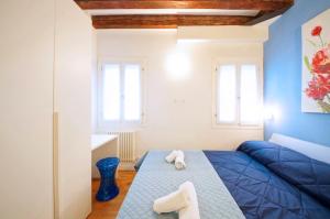 a bedroom with a blue bed with towels on it at DolceVita Apartments N. 502 Biennale in Venice