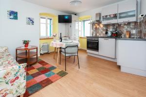 a kitchen and a living room with a table in a room at APARTMANI NAD VOLTUN in Kastav