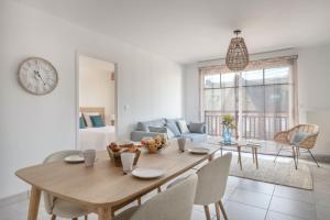 a dining room with a table and a living room at Coup de coeur pour un appartement en bord de mer à Pléneuf-Val-André in Pléneuf-Val-André