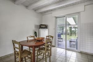 - une cuisine avec une table et des chaises en bois dans la chambre dans l'établissement Un écrin de verdure dans le Golfe du Morbihan à 200m de la plage, à Sarzeau