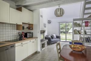 - une cuisine et une salle à manger avec une table et un canapé dans l'établissement Un écrin de verdure dans le Golfe du Morbihan à 200m de la plage, à Sarzeau