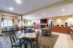 a restaurant with tables and chairs and a kitchen at Baymont by Wyndham Omaha SW in Omaha