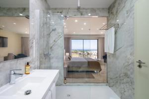 a bathroom with a shower and a bed in a bedroom at Lagos Atlantic Hotel in Lagos