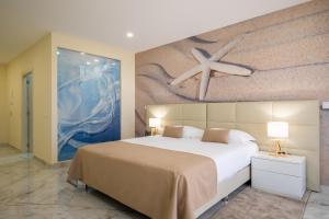 a bedroom with a large bed with a painting on the wall at Lagos Atlantic Hotel in Lagos