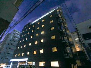 Un grand bâtiment avec des lumières au-dessus dans l'établissement HOTEL LiVEMAX Okayama West, à Okayama
