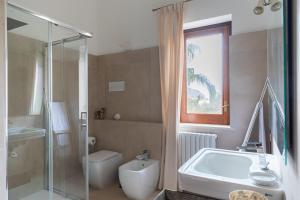 a bathroom with a tub and a toilet and a shower at Domus Orestea Luxury Suites in Palermo