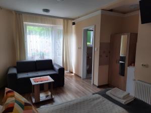 a living room with a black couch and a window at Sunset in Palić