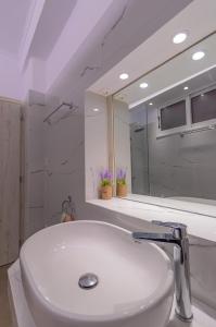 a bathroom with a white sink and a mirror at Flora's Apartment! in Zakynthos Town