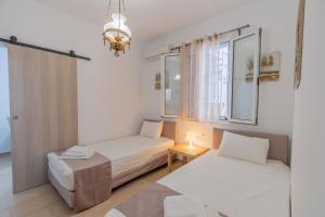 a small room with two beds and a window at Flora's Apartment! in Zakynthos Town