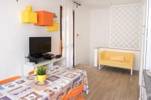 een woonkamer met een tafel en een televisie bij M301 - Marcelli, deliziosa villetta a schiera in posizione tranquilla in Marcelli