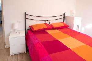 een kleurrijk bed met 2 kleurrijke kussens erop bij M301 - Marcelli, deliziosa villetta a schiera in posizione tranquilla in Marcelli