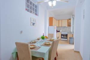 a kitchen and dining room with a table and chairs at Flora's Apartment! in Zakynthos Town