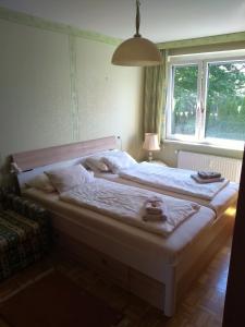 a bedroom with a large white bed with a window at Evita Wörthersee in Krumpendorf am Wörthersee