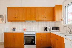 a kitchen with wooden cabinets and a stove top oven at Villa Vakirli in Loutra