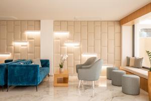 a living room with a blue couch and two chairs at Lagos Atlantic Hotel in Lagos