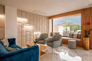 a living room with a blue couch and chairs at Lagos Atlantic Hotel in Lagos
