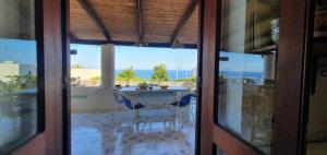 a view of a table and chairs through a glass door at Villa Cappero in Santa Marina Salina
