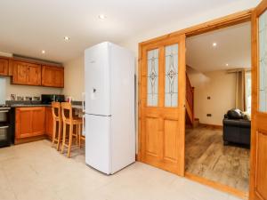 a kitchen with a white refrigerator in a room at 1 Greenway in Cinderford