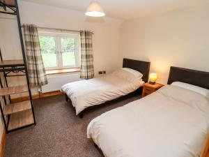 1 dormitorio con 2 camas, ventana y espejo en 1 Greenway, en Cinderford