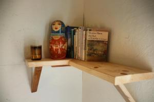 una estantería de madera con libros y un jarrón y una vela en Dom Žaba - Spreewaldatmosphäre im neu renovierten Bauwagen, en Burg