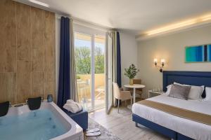 a hotel room with a bed and a bath tub at Golden Hotel in Marina di Cecina