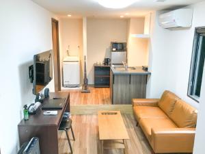 un soggiorno con divano e cucina di HOTEL LiVEMAX BUDGET Nagoya Shinkansen-guchi a Nagoya