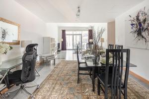 a dining room with a glass table and black chairs at Frank Porter - Marina Terrace in Dubai