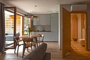 a kitchen and dining room with a table and chairs at Apartament Baltic Park Stegna - taras in Stegna +6 photos