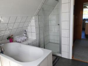リュベナウにあるFerienwohnung Sonnendeck Spreewaldの白いバスルーム(バスタブ、シャワー付)