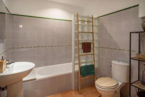 a bathroom with a toilet and a tub and a sink at Casa Mistral, Un paraíso de Mar y Montaña in Valldemossa