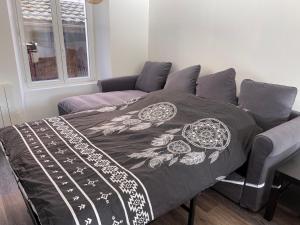 uma cama com um cobertor num quarto em Le 33 em Belfort