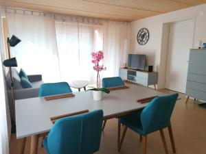 a living room with a table and blue chairs at Easy-Living Kriens Apartments in Lucerne