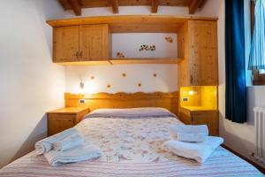 - une chambre avec un lit et 2 serviettes dans l'établissement Camping Al Lago Appartamento 4, à Pieve Di Ledro