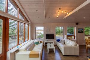 un soggiorno con divani bianchi e TV di Gorgeous Riverside Lodge in the South of Iceland a Reykholt