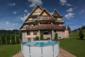 a large house with a hot tub in front of it at Dom Wczasowy Jesionkówka in Poronin